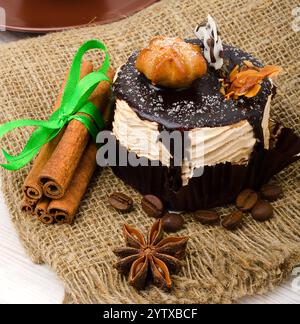 Karamellkuchen, Mousse-Dessert auf Sackleinen. Garniert mit Zimtstangen, Sternanis und Kaffeebohnen. Stockfoto