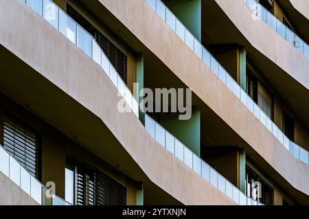 Modernes Wohngebäude mit geräumigen Balkonen und Glasgeländern in urbaner Umgebung Stockfoto