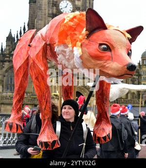 Manchester, Großbritannien, 8. Dezember 2024. Farbenfrohe, festliche Teilnehmer der Weihnachtsparade von Manchester, die jetzt im dritten Jahr stattfindet, verließen die Kathedrale von Manchester am Sonntag, den 8. Dezember, um 13:00 Uhr, um eine Führung durch das Stadtzentrum zu Unternehmen, bei der die Menschenmassen unterhielten. Der Stadtrat von Manchester organisierte die Parade zusammen mit Gruppen wie Walk the Plank, Global Grooves, Handmade Parade und Fools Paradise. Quelle: Terry Waller/Alamy Live News Stockfoto