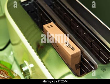 Paris, Frankreich - 22. November 2021: Ein Amazon-Karton in einem Toaster, der eine humorvolle und ungewöhnliche Szene in einer Küche schafft Stockfoto