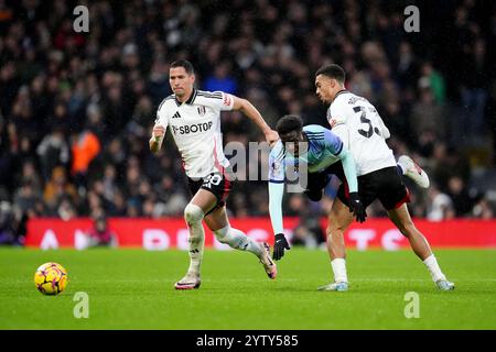 Arsenals Bukayo Saka (Mitte) kämpft um den Ball mit Fulhams Sasa Lukic (links) und Antonee Robinson (rechts) während des Premier League-Spiels in Craven Cottage, London. Bilddatum: Sonntag, 8. Dezember 2024. Stockfoto