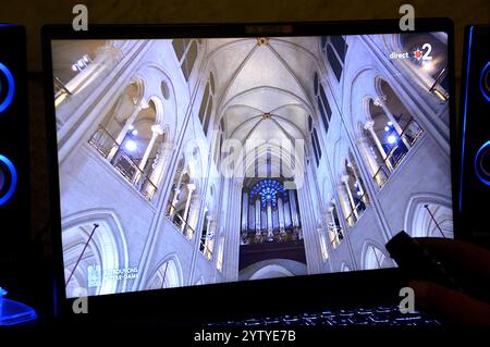 Paris, Frankreich. Dezember 2024. Ein Mann beobachtet die Wiedereröffnung der Kathedrale Notre Dame in Paris auf seinem Computer. Wiedereröffnungszeremonie der Kathedrale Notre-Dame de Paris. Fünf Jahre nach dem gigantischen Brand, der Notre-Dame de Paris verwüstete, hat die Kathedrale nach einer titanic-Baustelle endlich ihre Pforten wieder geöffnet. (Credit Image: © Gerard Bottino/SOPA Images via ZUMA Press Wire) NUR REDAKTIONELLE VERWENDUNG! Nicht für kommerzielle ZWECKE! Stockfoto