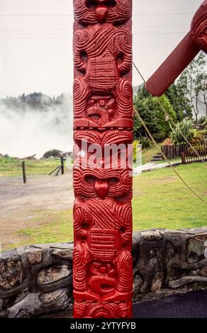 Whakarewarewa, ein lebendiges Maori-Dorf auf der Nordinsel Neuseelands und Heimat der Tūhourangi Ngāti Wāhiao. Archivfoto aus dem Jahr 1991 von dem geschnitzten Totempfahl vor dem Tamatekapua-Versammlungshaus, das auch das Haus der Ahnen genannt wird Stockfoto