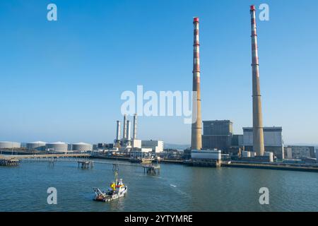 Weite Sicht auf die Poolbeg-Generationsstation vor einem blauen Himmel am frühen Morgen. Der Bahnhof befindet sich in Ringsend an der Southbank des Hafens Dublin. Stockfoto