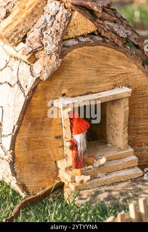 Handgefertigtes Spielzeughaus einer weihnachtselve im Stamm eines Baumes zur Dekoration, Weihnachtsdekoration zum Verkauf Stockfoto