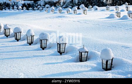 Kleine Laternen auf finnischen Kriegsgräbern im Winter Stockfoto