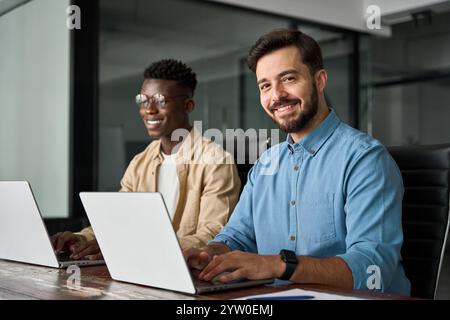 Professioneller junger glücklicher Geschäftsmann, der mit einem Kollegen im Büro arbeitet, Porträt. Stockfoto