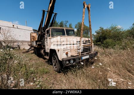 Verlassener Bauwagen umgeben von bewachsener Vegetation. Stockfoto