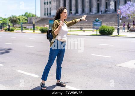 Dynamische Frau winkt, um ein Taxi auf der Straße zu rufen Stockfoto