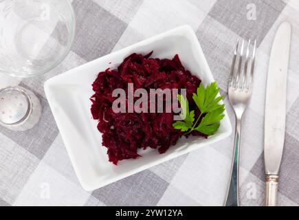 Salat aus geriebener, gebackener Rote Bete auf dem Teller mit frischer Petersilie Stockfoto