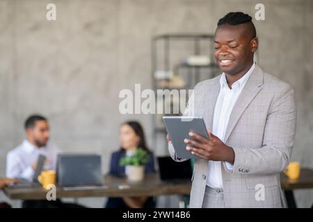 Teammitglieder arbeiten in einer modernen Büroumgebung mit digitalen Geräten zusammen Stockfoto