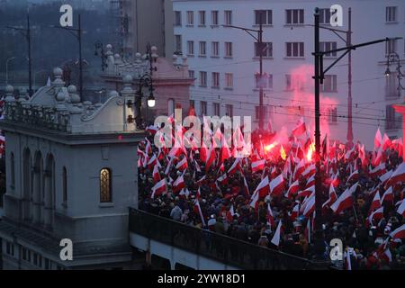 märz des Unabhängigkeitstages in Warschau am 11. November 2022. Menschenmassen, in polnische Fahnen gewickelt und in Rot und weiß gekleidet. Stockfoto