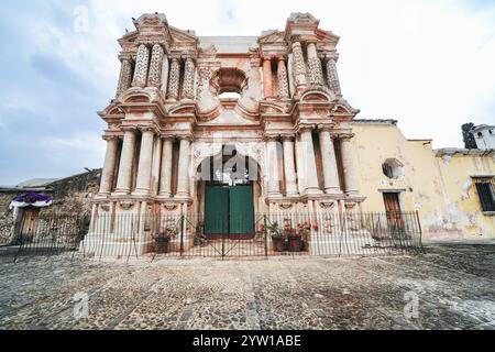 Außenfassade der Ruinen der Iglesia de Nuestra Señora de El Carmen oder der Kirche unserer Lieben Frau von Carmen, einer kunstvollen katholischen Kirche, die 1773 durch die Erdbeben in Santa Marta in Antigua, Guatemala, zerstört wurde. Vor den Ruinen findet oft ein wöchentlicher Kunsthandwerksmarkt statt. Stockfoto