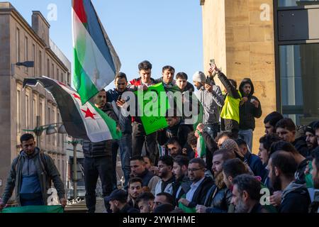 Glasgow, Schottland, Großbritannien. Dezember 2024. Eine Menschenmenge versammelt sich auf den Stufen der Buchanan-Straße, um den Fall der syrischen Regierung zu feiern, während Präsident Baschar al-Assad vor Rebellen flüchtet. Assad ist Präsident seit Juli 2000. Gutschrift R.. Gass/Alamy Live News Credit: Richard Gass/Alamy Live News Stockfoto