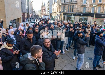 Glasgow, Schottland, Großbritannien. Dezember 2024. Eine Menschenmenge versammelt sich auf den Stufen der Buchanan-Straße, um den Fall der syrischen Regierung zu feiern, während Präsident Baschar al-Assad vor Rebellen flüchtet. Assad ist Präsident seit Juli 2000. Gutschrift R.. Gass/Alamy Live News Credit: Richard Gass/Alamy Live News Stockfoto