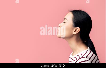 Seitenansicht Porträt Einer Jungen Asiatischen Frau, Die Air Kiss Sendet Stockfoto