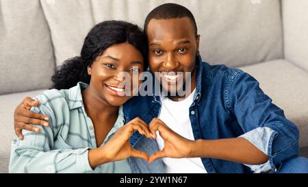 Porträt Eines Fröhlichen Romantischen Afroamerikanischen Paares, Das Eine Herzensgeste Vor Der Kamera Macht Stockfoto