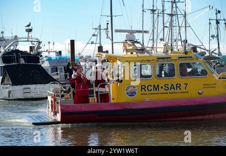 Richmond, Kanada. Dezember 2024. Ein Mann, der als Weihnachtsmann verkleidet ist, kommt mit dem Boot an der Steveston Fisherman's Wharf in Richmond, British Columbia, Kanada, am 8. Dezember 2024 an. Die Ankunft des Weihnachtsmanns mit dem Boot fand hier am Sonntag statt, um die Weihnachtszeit zu beginnen. Quelle: Liang Sen/Xinhua/Alamy Live News Stockfoto