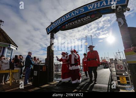 Richmond, Kanada. Dezember 2024. Ein Mann, der als Weihnachtsmann verkleidet ist, kommt am 8. Dezember 2024 an der Steveston Fisherman's Wharf in Richmond, British Columbia, Kanada. Die Ankunft des Weihnachtsmanns mit dem Boot fand hier am Sonntag statt, um die Weihnachtszeit zu beginnen. Quelle: Liang Sen/Xinhua/Alamy Live News Stockfoto