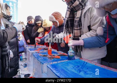 Harbin, China. 7. Dezember 2024. Das 5. Harbin Ice Harvesting Festival beginnt am Nordufer des Songhua River in Harbin, der Hauptstadt der nordöstlichen chinesischen Provinz Heilongjiang, am 7. Dezember 2024. Quelle: Zhao Yuhang/China News Service/Alamy Live News Stockfoto