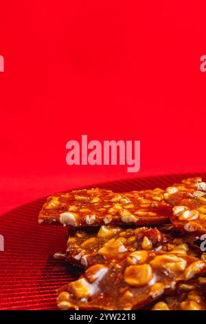 Hausgemachte Zuckerkekse mit Nüssen auf einem glänzenden roten Teller Stockfoto