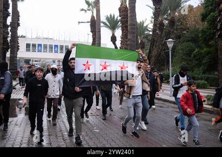 Izmir, Türkei. Dezember 2024. Eine syrische Gruppe marschiert mit der Flagge der syrischen Nationalarmee. Der Sturz der Regierung von Baschar al-Assad mit dem Einzug von Hayat Tahrir al-Sham nach Damaskus hat Millionen syrischer Flüchtlinge, die in der Türkei leben, auf die Straße gebracht. Die in Izmir lebenden Syrer gingen auf die Straße und zeigten ihre Freude. Quelle: SOPA Images Limited/Alamy Live News Stockfoto