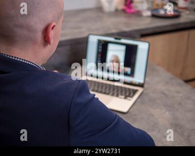 Geschäftsleute und Kollegen können Videokonferenzen von zu Hause aus in einer modernen Küche durchführen und geschäftliche Angelegenheiten auf einem Laptop aus der Ferne diskutieren Stockfoto