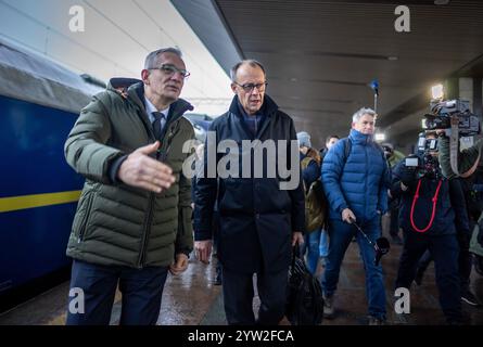 Kiew, Ukraine. Dezember 2024. Friedrich Merz (M), Bundeskanzlerkandidat und CDU-Bundesvorsitzender, wird am Bahnhof in Kiew von Martin Jäger, Deutschlands Botschafter in der Ukraine, begrüßt. Merz bleibt einen Tag in der ukrainischen Hauptstadt. Quelle: Michael Kappeler/dpa/Alamy Live News Stockfoto