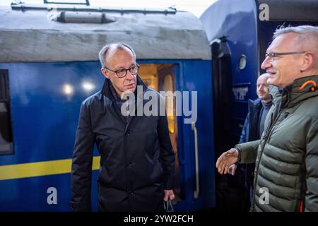 Kiew, Ukraine. Dezember 2024. Friedrich Merz (l), CDU-Kanzler und CDU-Bundesvorsitzender, wird am Bahnhof in Kiew von Martin Jäger, Deutschlands Botschafter in der Ukraine, begrüßt. Merz verbringt einen Tag in der ukrainischen Hauptstadt. Quelle: Michael Kappeler/dpa/Alamy Live News Stockfoto