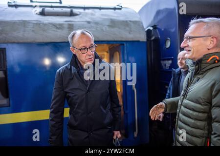 Kiew, Ukraine. Dezember 2024. Friedrich Merz (l), CDU-Kanzler und CDU-Bundesvorsitzender, wird am Bahnhof in Kiew von Martin Jäger, Deutschlands Botschafter in der Ukraine, begrüßt. Merz verbringt einen Tag in der ukrainischen Hauptstadt. Quelle: Michael Kappeler/dpa/Alamy Live News Stockfoto