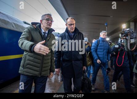 Kiew, Ukraine. Dezember 2024. Friedrich Merz (M), Bundeskanzlerkandidat und CDU-Bundesvorsitzender, wird am Bahnhof in Kiew von Martin Jäger, Deutschlands Botschafter in der Ukraine, begrüßt. Merz bleibt einen Tag in der ukrainischen Hauptstadt. Quelle: Michael Kappeler/dpa/Alamy Live News Stockfoto