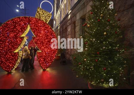 Nicht exklusiv: CHARKIW, UKRAINE - 7. DEZEMBER 2024 - Menschen stehen während der Weihnachtszeit unter einer glühenden Installation, Charkiw, nordöstlicher Ukra Stockfoto