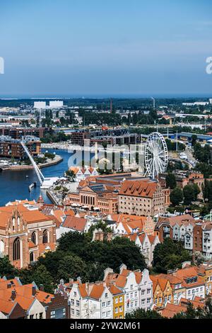 Blick aus der Vogelperspektive auf farbenfrohe historische Gebäude und Riesenrad in Danzig. Pulsierende Stadtlandschaft mit roten Dächern und Grün. Danzig, Polen - 19. Mai Stockfoto
