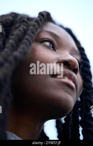 Eine junge Frau mit geflochtenen Haaren schaut in den Himmel mit einem Ausdruck der Hoffnung und Sehnsucht, Brandenburg, Deutschland Stockfoto