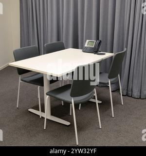 Kleiner Konferenzraum mit Tisch und vier Stühlen Stockfoto