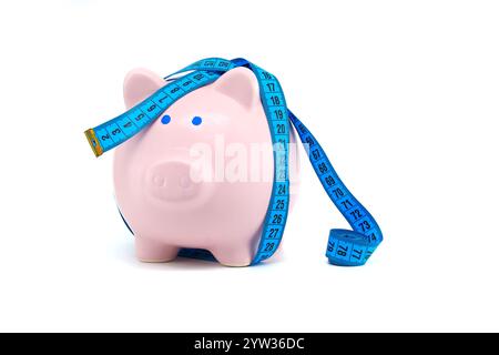 Eine kreative Darstellung des Sparens von Geld, mit einer pinkfarbenen Schweinebank, die in ein Maßband gewickelt ist. Perfekt für Finanzthemen und Budgetierung. Stockfoto