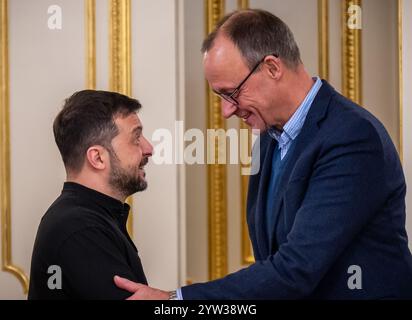 Kiew, Ukraine. Dezember 2024. Friedrich Merz (r), Bundeskanzlerkandidat und CDU-Bundesvorsitzender, steht neben dem ukrainischen Präsidenten Wolodymyr Zelenski vor einer gemeinsamen Sitzung im Präsidialamt. Merz verbringt einen Tag in der ukrainischen Hauptstadt. Quelle: Michael Kappeler/dpa/Alamy Live News Stockfoto