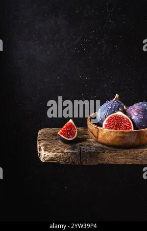 Frische Feigen in einer Holzschale auf dunklem Hintergrund Stockfoto