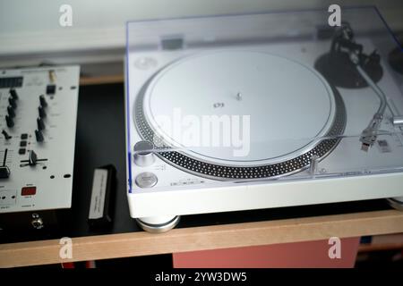 Nahaufnahme eines modernen Plattenspielers mit DJ-Ausrüstung auf einem Schreibtisch, der die komplizierten Details und Bedienelemente für die Musikwiedergabe hervorhebt. Stockfoto