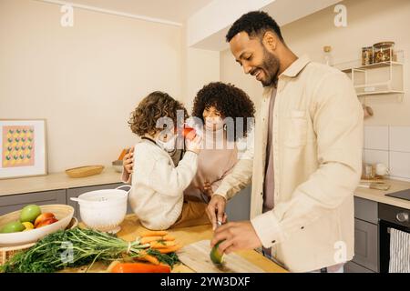 Eine glückliche Familie versammelt sich in einer hellen Küche und teilt einen Moment, während sie gemeinsam eine Mahlzeit zubereiten. Stockfoto