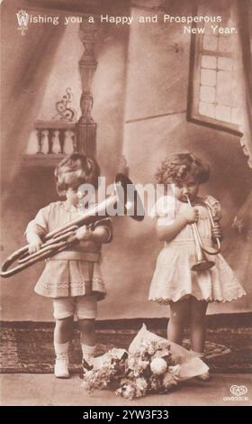 Happy New Year-Karte mit Trompetenspielen für Jungen und Mädchen Stockfoto