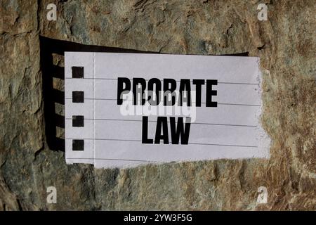 Nachricht zum Nachlassgesetz geschrieben auf zerrissenem Papierstück mit Steinhintergrund. Symbol für das konzeptionelle Nachlassgesetz. Kopierbereich. Stockfoto