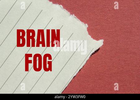 Hirnnebelbotschaft auf gerissenem, liniertem Papier mit rotem Hintergrund. Konzeptionelles Hirnnebelsymbol. Kopierbereich. Stockfoto