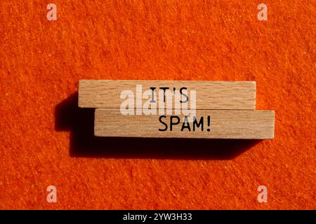 Es ist eine Spam-Nachricht auf Holzblöcken mit orangem Hintergrund. Konzeptionell ist das Spam-Symbol. Kopierbereich. Stockfoto