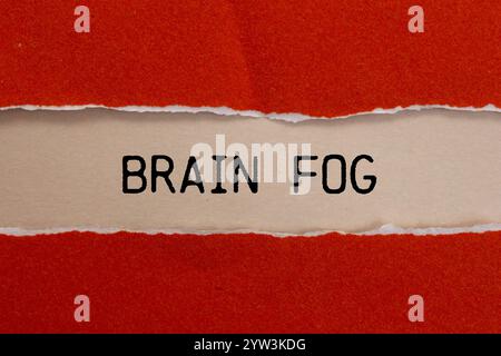 Hirnnebelbotschaft auf gerissenem rotem Papier mit beigem Hintergrund. Konzeptionelles Hirnnebelsymbol. Kopierbereich. Stockfoto