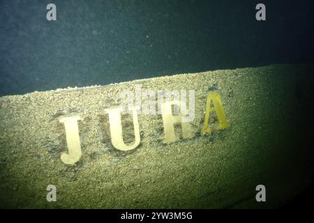 Die Schrift „Jura“ ist auf einem verwitterten Schiffswrack zu sehen, das mit Muscheln, Quagga-Dreieckmuscheln (Dreissena rostriformis bugensis), invasiver spe bedeckt ist Stockfoto