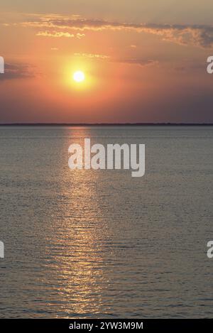 Sonnenuntergang über der ruhigen Nordsee, die Umrisse der Insel Juist am Horizont, Norddeich, Niedersachsen, Deutschland, Europa Stockfoto