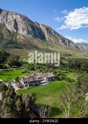 Großes Haus, Gebäude, hellgrüner Rasen, Hotelgelände, blauer Himmel. Oktober in der Hermanus Klein River Lagune, Kleinriversvlei, Riversvlei, Südafrika. Stockfoto