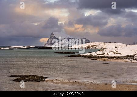 Der Blick von einem Strand auf der Insel Sommaroy auf die felsige Insel Haja im Winter, Tromso, Troms, Norwegen, Europa Stockfoto