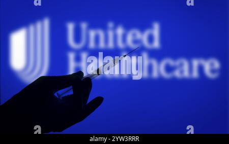 Dhaka, Bangladesch, 06. Dezember 2024: Eine Hand mit Handschuhen, die eine Spritze vor dem UnitedHealthcare-Logo hält. UnitedHealth Group Incorporated ist ein US-amerikanischer Stockfoto